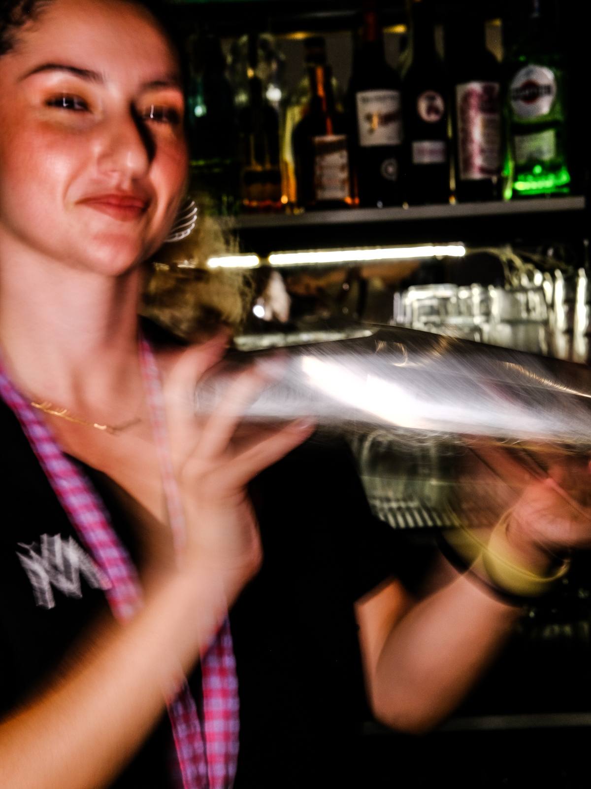 Bartender colando un cóctel detrás de la barra